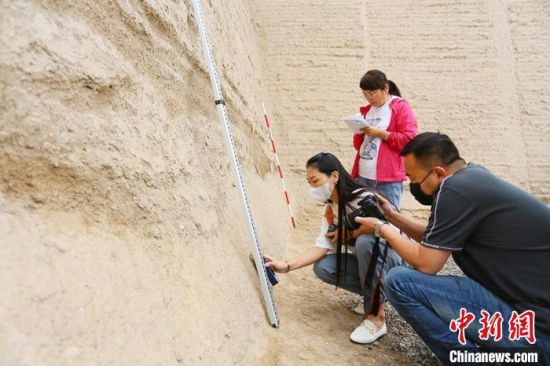 科技保護讓長城價值的真實性和完整性得到有效延續(xù)和傳承。圖為文物工作者正在測量關城的相關數(shù)據(jù)。　高展 攝