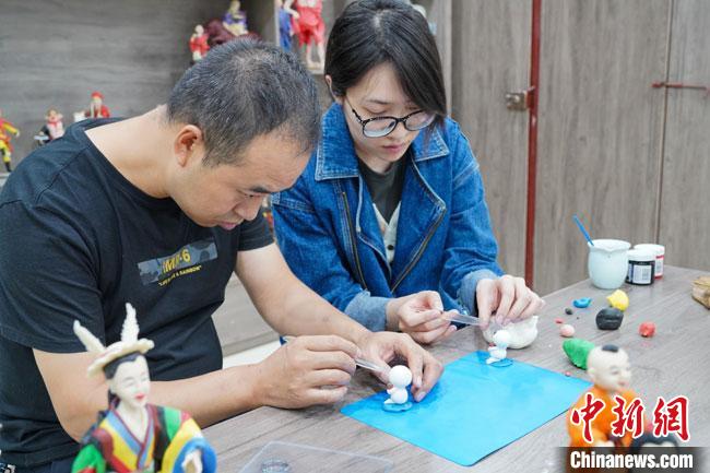 <a target='_blank'  data-cke-saved- >中新社</a>記者(右)現(xiàn)場體驗面塑制作過程?！￡悹帍?攝