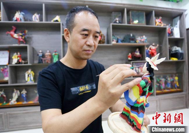 圖為安秋平正在創(chuàng)作代表隴南文縣民俗的《白馬人》作品?！「哒?攝