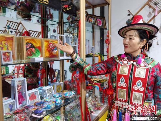 圖為身著民族服飾的隴原巧手展示手工藝品。(資料圖) 徐雪 攝