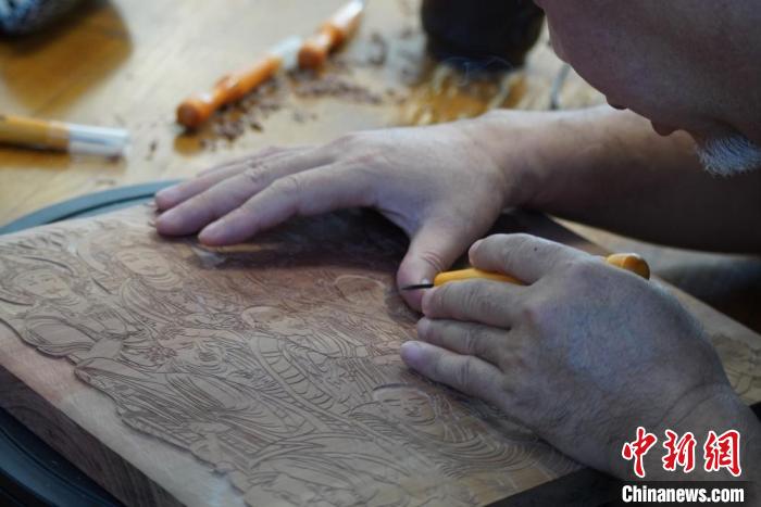 圖為徐晉林湊近木板，近距離制作雕版畫?！【琶赖┰?　攝