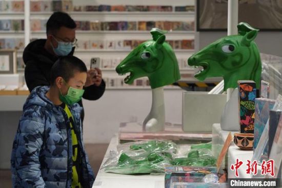 圖為“神馬來(lái)了”銅奔馬頭套吸引參觀者駐足。　九美旦增 攝