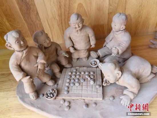圖為泥塑作品展現(xiàn)下棋場(chǎng)景。 劉玉桃 攝