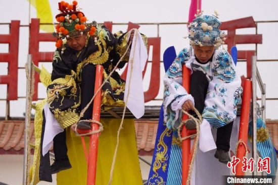 圖為“苦水高高蹺”表演者通過(guò)麻繩將腳固定在腳踏板，并在腿部纏繞六七圈。　九美旦增 攝