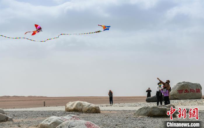 圖為市民正在陽關(guān)景區(qū)放風(fēng)箏。　王斌銀 攝