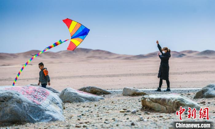 圖為市民正在陽關(guān)景區(qū)放風(fēng)箏。　王斌銀 攝