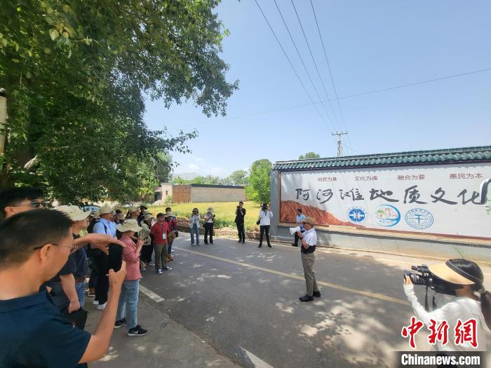 圖為中國地質(zhì)大學(北京)教授張緒教介紹村落情況?！『衍?攝