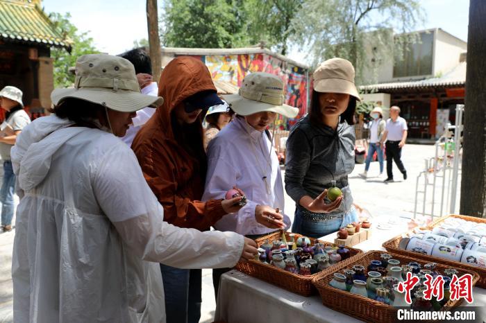 圖為民眾挑選手工藝產(chǎn)品?！⊙Φ?攝