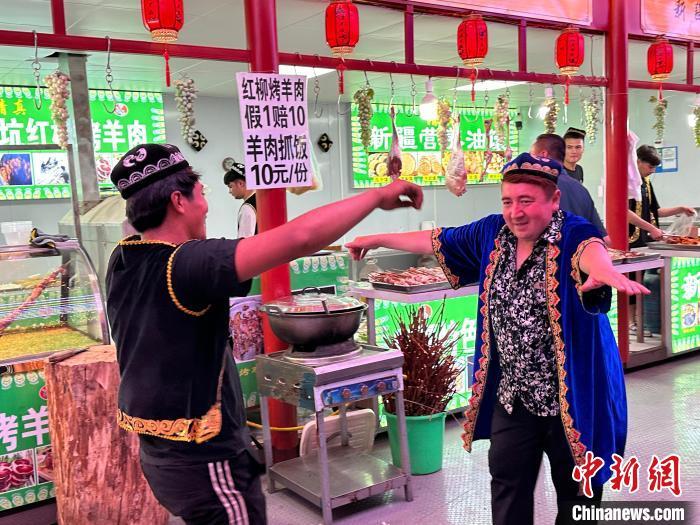 圖為餐飲經(jīng)營(yíng)者在“西涼不夜城”跳起舞蹈引客?！〈魑牟?攝</p><p>