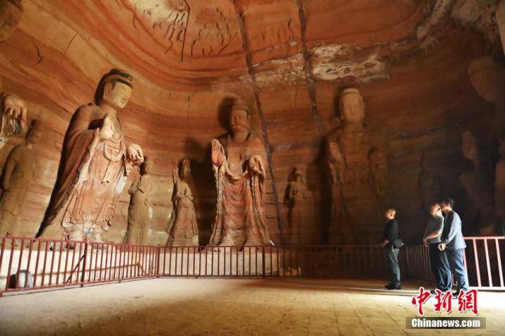 7月15日，游人參觀甘肅省平?jīng)鍪袥艽h百里石窟長(zhǎng)廊中的南石窟寺1號(hào)窟。百里石窟長(zhǎng)廊位于涇川縣境內(nèi)，由512個(gè)石窟、5眼窟中石井組成，現(xiàn)存王母宮石窟、鳳凰山石窟、南石窟寺、丈八寺石窟、羅漢洞石窟、太山寺石窟等規(guī)模較大的石窟群，還有數(shù)量眾多的小石窟群。南石窟寺開(kāi)鑿于北魏永平三年，其中1號(hào)窟屬于大型七佛窟，七佛高達(dá)6米。中新社記者 李亞龍 攝