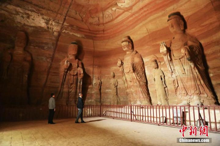 7月15日，游人參觀甘肅省平?jīng)鍪袥艽h百里石窟長(zhǎng)廊中的南石窟寺1號(hào)窟。百里石窟長(zhǎng)廊位于涇川縣境內(nèi)，由512個(gè)石窟、5眼窟中石井組成，現(xiàn)存王母宮石窟、鳳凰山石窟、南石窟寺、丈八寺石窟、羅漢洞石窟、太山寺石窟等規(guī)模較大的石窟群，還有數(shù)量眾多的小石窟群。南石窟寺開(kāi)鑿于北魏永平三年，其中1號(hào)窟屬于大型七佛窟，七佛高達(dá)6米。中新社記者 李亞龍 攝