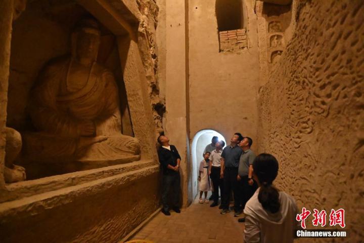 7月15日，游人參觀甘肅省平?jīng)鍪袥艽h百里石窟長(zhǎng)廊中的王母宮石窟。百里石窟長(zhǎng)廊位于涇川縣境內(nèi)，由512個(gè)石窟、5眼窟中石井組成，現(xiàn)存王母宮石窟、鳳凰山石窟、南石窟寺、丈八寺石窟、羅漢洞石窟、太山寺石窟等規(guī)模較大的石窟群，還有數(shù)量眾多的小石窟群。王母宮石窟又名千佛洞，該窟設(shè)計(jì)宏大，造像生動(dòng)，窟內(nèi)擁有造像數(shù)百尊，是較為珍貴的佛教文化歷史遺存。中新社記者 李亞龍 攝</p>
<p>