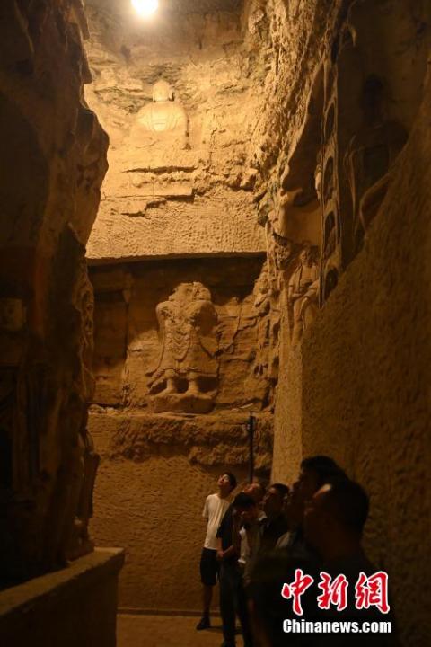 7月15日，游人參觀甘肅省平?jīng)鍪袥艽h百里石窟長(zhǎng)廊中的王母宮石窟。百里石窟長(zhǎng)廊位于涇川縣境內(nèi)，由512個(gè)石窟、5眼窟中石井組成，現(xiàn)存王母宮石窟、鳳凰山石窟、南石窟寺、丈八寺石窟、羅漢洞石窟、太山寺石窟等規(guī)模較大的石窟群，還有數(shù)量眾多的小石窟群。王母宮石窟又名千佛洞，該窟設(shè)計(jì)宏大，造像生動(dòng)，窟內(nèi)擁有造像數(shù)百尊，是較為珍貴的佛教文化遺存。中新社記者 李亞龍 攝</p>
<p>