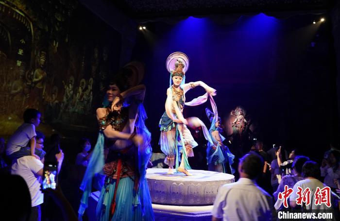 《樂動敦煌》是全球首部洞窟式沉浸體驗劇，利用真人與數(shù)字影像虛實交換實現(xiàn)沉浸式體驗。圖為2023年8月28日晚，《樂動敦煌》演出。(資料圖)中新社記者 毛建軍 攝