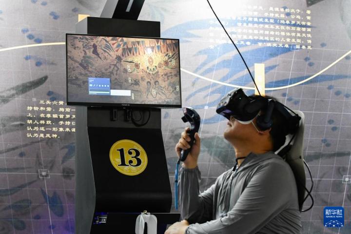 7月22日，游客借助VR設(shè)備沉浸式游覽莫高窟第285窟虛擬場(chǎng)景。新華社記者 郎兵兵 攝